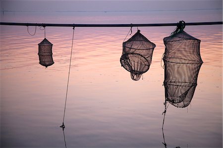 Silhouette of fishing nets over still water Photographie de stock - Premium Libres de Droits, Code: 649-06533586
