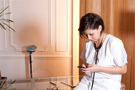 Doctor using cell phone in office Foto de stock - Sin royalties Premium, Código: 649-06621954