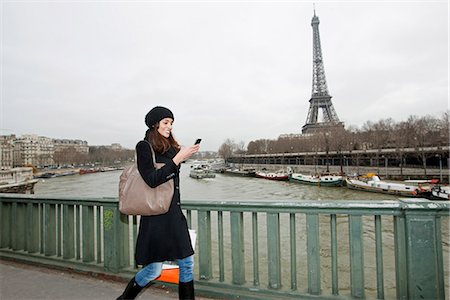 eiffel tower - Woman using cell phone on waterfront Stock Photo - Premium Royalty-Free, Code: 649-06621985