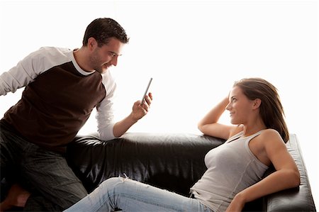 Man taking picture of girlfriend on sofa Foto de stock - Sin royalties Premium, Código: 649-06622018