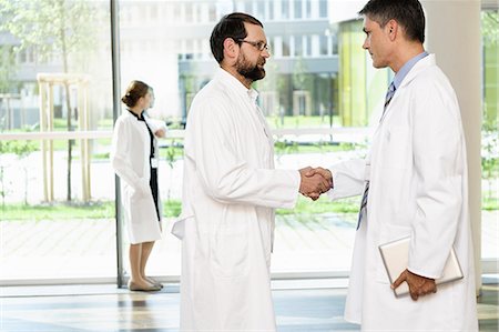 simsearch:649-06829489,k - Doctors shaking hands in hallway Photographie de stock - Premium Libres de Droits, Code: 649-06622099