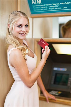 Smiling woman using ATM Stock Photo - Premium Royalty-Free, Code: 649-06622173