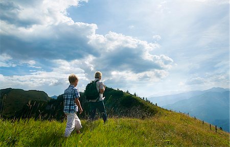 father and son trekking - Father and son hiking on grassy hilltop Stock Photo - Premium Royalty-Free, Code: 649-06622340