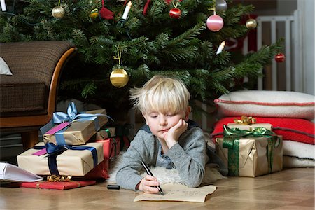 simsearch:649-06622586,k - Boy writing under Christmas tree Photographie de stock - Premium Libres de Droits, Code: 649-06622467