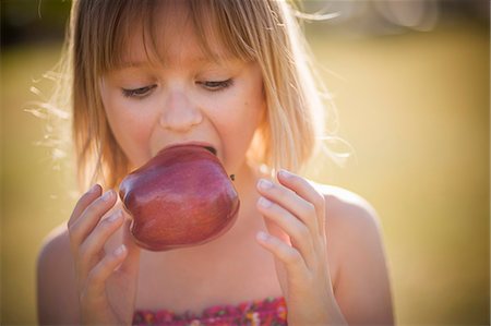 simsearch:695-03380342,k - Girl eating apple outdoors Photographie de stock - Premium Libres de Droits, Code: 649-06622476