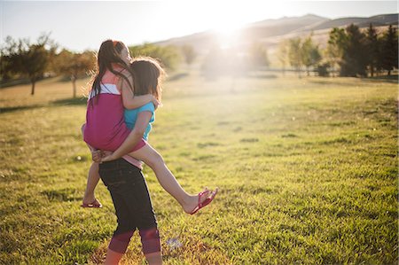 piggy back ride - Girl carrying friend piggyback in field Stock Photo - Premium Royalty-Free, Code: 649-06622487