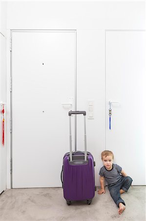 Boy by rolling luggage in hallway Photographie de stock - Premium Libres de Droits, Code: 649-06622517