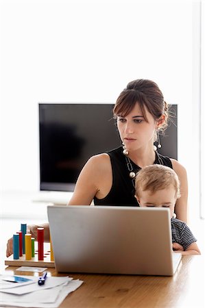 family in living room - Businesswoman working at home Stock Photo - Premium Royalty-Free, Code: 649-06622533