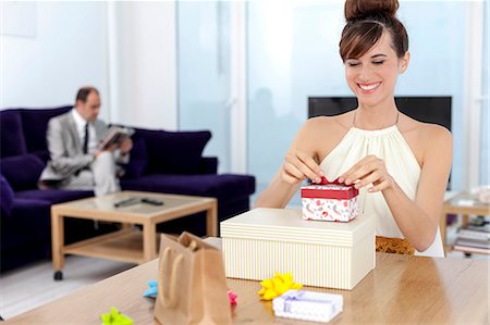 Woman opening presents at table Foto de stock - Sin royalties Premium, Código: 649-06622573