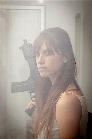 Woman holding machine gun at window Photographie de stock - Premium Libres de Droits, Code: 649-06622580