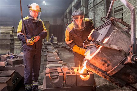 ropa de protección - Workers pouring molten metal in foundry Foto de stock - Sin royalties Premium, Código: 649-06622814