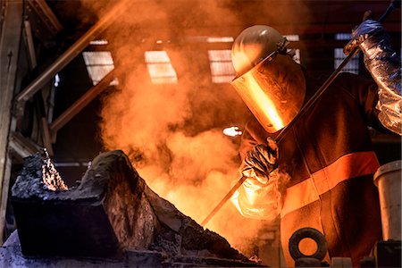protective clothing - Worker stirring molten metal in foundry Stock Photo - Premium Royalty-Free, Code: 649-06622875