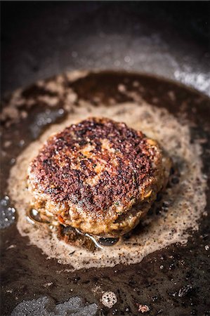 simsearch:695-05773485,k - Close up of meat frying in pan Foto de stock - Royalty Free Premium, Número: 649-06622957