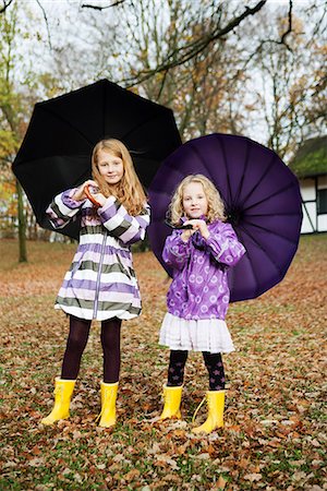 rubber boots family - Girls in rain boots and umbrellas in park Stock Photo - Premium Royalty-Free, Code: 649-06623072