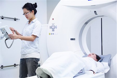 serious standing female - Technician with patient in CT scanner Stock Photo - Premium Royalty-Free, Code: 649-06623114