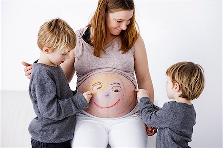 parents and child hugging - Children drawing on pregnant mother Stock Photo - Premium Royalty-Free, Code: 649-06623155