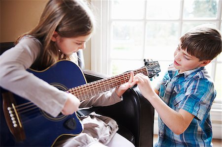 Boy helping girl play guitar Stock Photo - Premium Royalty-Free, Code: 649-06716501