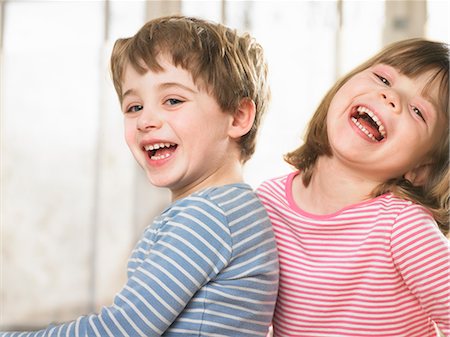 simsearch:649-06433353,k - Children smiling together indoors Photographie de stock - Premium Libres de Droits, Code: 649-06716543