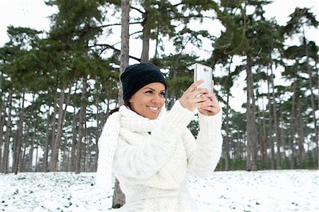 simsearch:649-06621981,k - Woman taking picture in snowy forest Fotografie stock - Premium Royalty-Free, Codice: 649-06716643