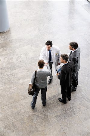 successful businessman standing photo - Business people and doctor greeting Stock Photo - Premium Royalty-Free, Code: 649-06716702