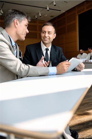 simsearch:649-06716753,k - Businessmen using tablet computer at desk Stock Photo - Premium Royalty-Free, Code: 649-06716758