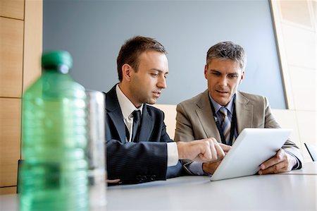 simsearch:649-06305004,k - Businessmen using tablet computer at desk Stock Photo - Premium Royalty-Free, Code: 649-06716753