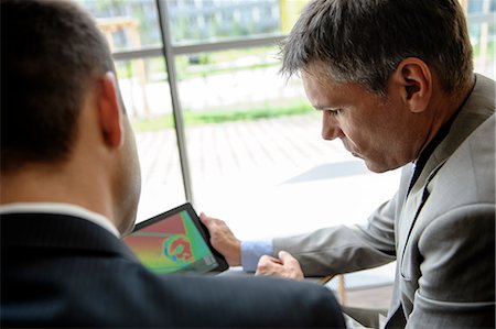 Businessmen using tablet computer at desk Fotografie stock - Premium Royalty-Free, Codice: 649-06716760