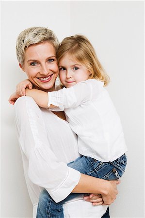 studio portrait white background - Smiling mother and daughter hugging Stock Photo - Premium Royalty-Free, Code: 649-06716783