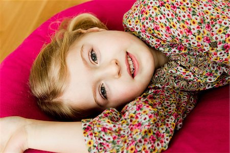 Smiling girl laying on pillow Photographie de stock - Premium Libres de Droits, Code: 649-06716801