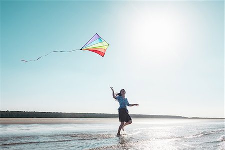 full length 40s woman alone - Woman flying kite on beach Stock Photo - Premium Royalty-Free, Code: 649-06716894