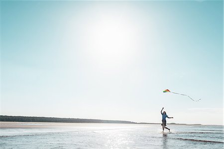 simsearch:649-06716899,k - Woman flying kite on beach Foto de stock - Royalty Free Premium, Número: 649-06716893