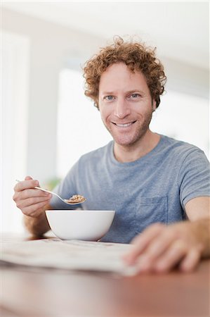 eat with cereal bowl with spoon - Man reading newspaper at breakfast Stock Photo - Premium Royalty-Free, Code: 649-06716949