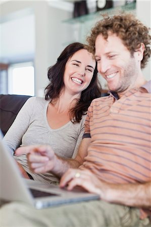 female computer laughing - Couple using laptop together on sofa Stock Photo - Premium Royalty-Free, Code: 649-06716973