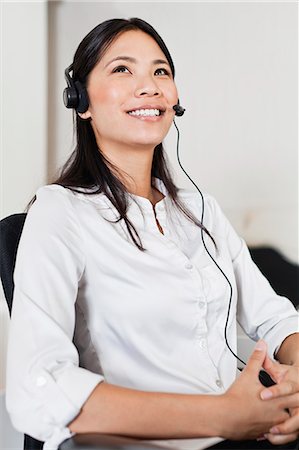 phone headset - Businesswoman wearing headset at desk Stock Photo - Premium Royalty-Free, Code: 649-06717033