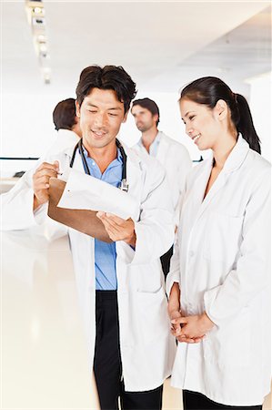 Doctor reading his notes to colleague Stock Photo - Premium Royalty-Free, Code: 649-06717121