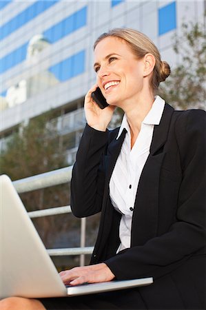 Businesswoman using laptop outdoors Foto de stock - Sin royalties Premium, Código: 649-06717170