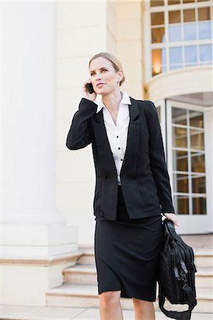 smiling blond woman in business suit - Businesswoman talking on cell phone Foto de stock - Sin royalties Premium, Código: 649-06717172