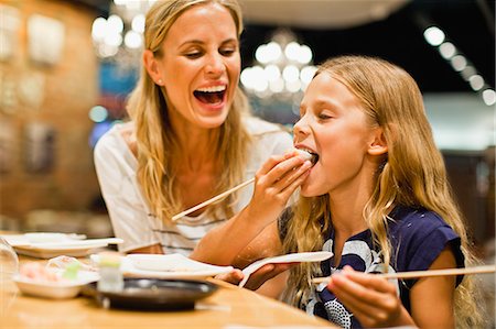 eating (people eating) - Mother and daughter using chopsticks Foto de stock - Sin royalties Premium, Código: 649-06717215