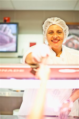 Butcher smiling at counter Photographie de stock - Premium Libres de Droits, Code: 649-06717224