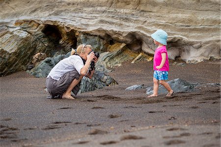 squat - Mother taking picture of daughter on beach Stock Photo - Premium Royalty-Free, Code: 649-06717316
