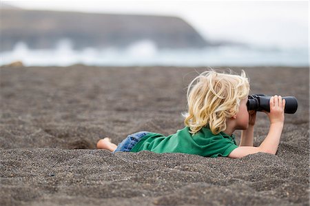 simsearch:649-06717318,k - Boy using binoculars on beach Foto de stock - Royalty Free Premium, Número: 649-06717318