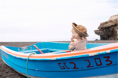 sunhat - Toddler girl sitting in boat on beach Stock Photo - Premium Royalty-Free, Code: 649-06717331