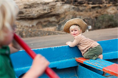 siblings blond - Toddler girl sitting in boat on beach Stock Photo - Premium Royalty-Free, Code: 649-06717333