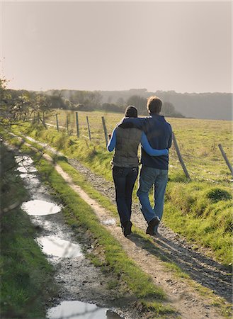 simsearch:649-03882395,k - Couple walking on rural road Foto de stock - Royalty Free Premium, Número: 649-06717413