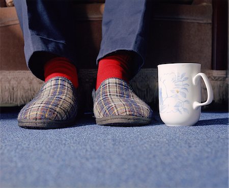 Mans feet in slippers with mug of tea Foto de stock - Sin royalties Premium, Código: 649-06717432