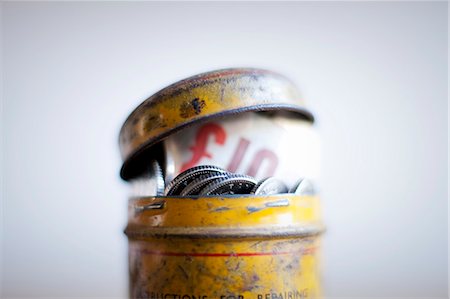 Antique tin full of money on desk Foto de stock - Royalty Free Premium, Número: 649-06717476