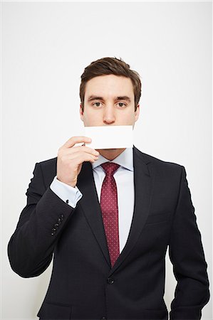 simsearch:649-06717595,k - Businessman holding blank card over his face Foto de stock - Sin royalties Premium, Código: 649-06717568