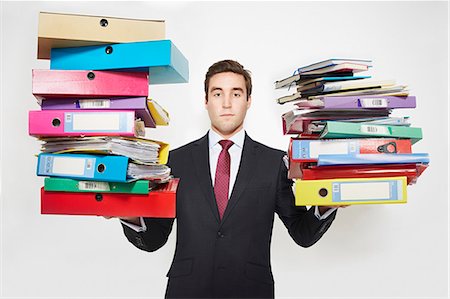 Businessman balancing stacks of folders Stock Photo - Premium Royalty-Free, Code: 649-06717580