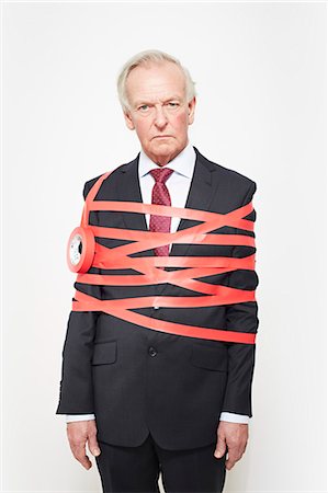 simsearch:649-06717593,k - Businessman wrapped in red tape Foto de stock - Sin royalties Premium, Código: 649-06717596