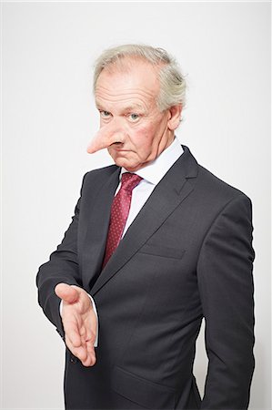 deshonestidad - Businessman with long nose offering hand Photographie de stock - Premium Libres de Droits, Code: 649-06717599